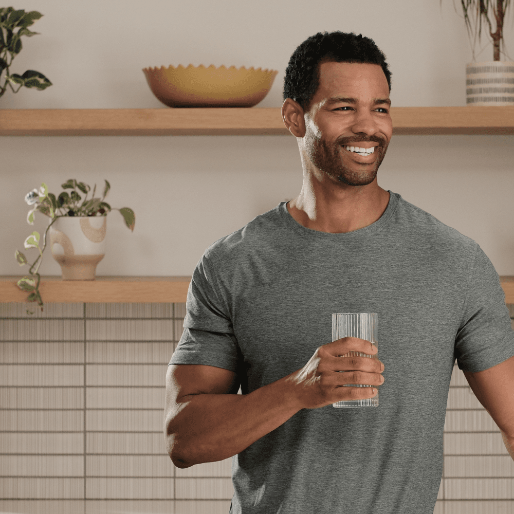 Man with surfboard running into the ocean waves.