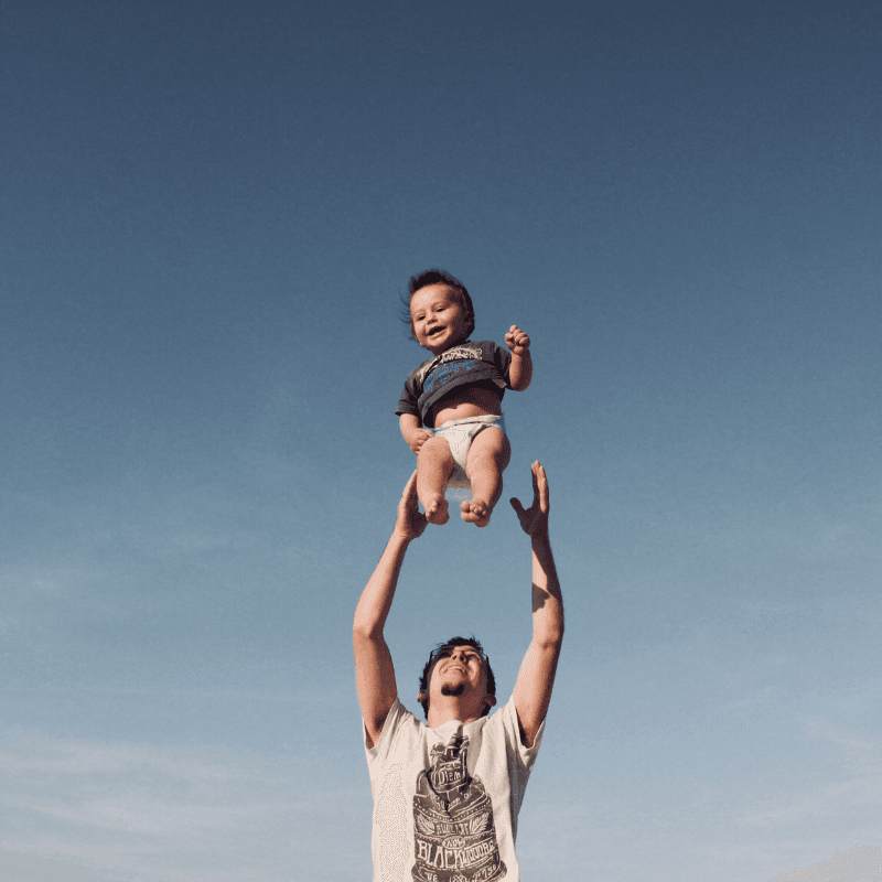 Dad throwing son playfully into the air